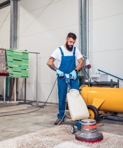 Professional worker doing his job at carpet washing service.